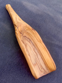 Pala de madera de olivo en uso, sirviendo semillas